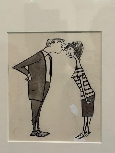 This photo captures a framed cartoon drawing displayed on a wall, likely within a museum on Museumstraat, Zuid, Amsterdam